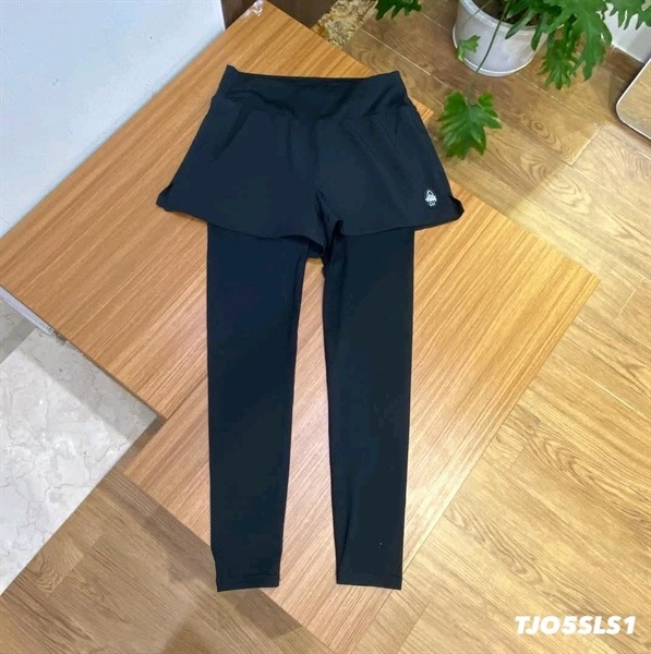 Quần legging đen có lớp short ngoài, trải phẳng toàn thân trên bàn gỗ, nhìn từ trên xuống