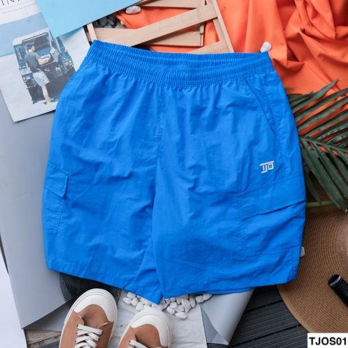 Quần short túi hộp màu xanh dương trải phẳng mặt trước, lưng thun, túi hộp hai bên, logo nhỏ thêu