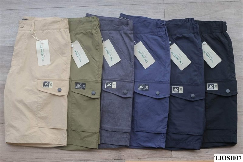 Sáu chiếc quần short túi hộp xếp cạnh nhau: be, xanh lá, xanh jean, xanh navy, navy đậm, đen, có treo tag giấy